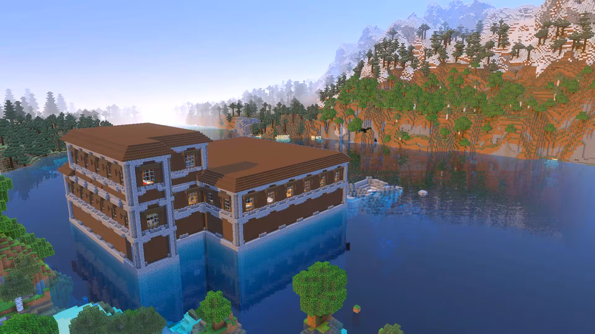 image of a Minecraft seed with a woodland mansion on lake overlooking jagged peaks mountain range
